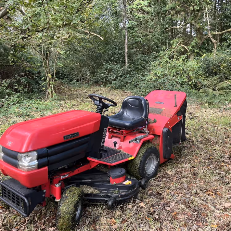 A red sit on lawn mower in a garden
