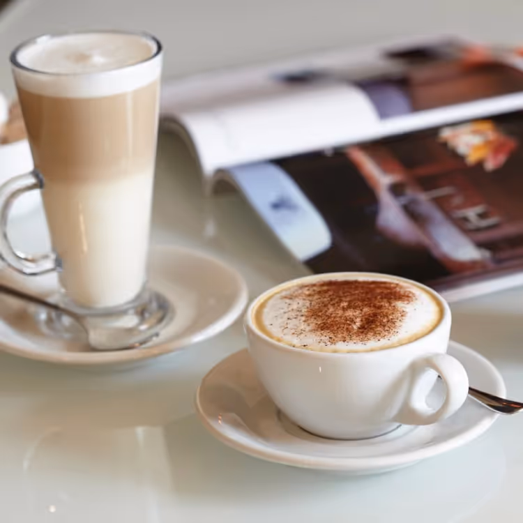 Two coffees and a magazine on a table