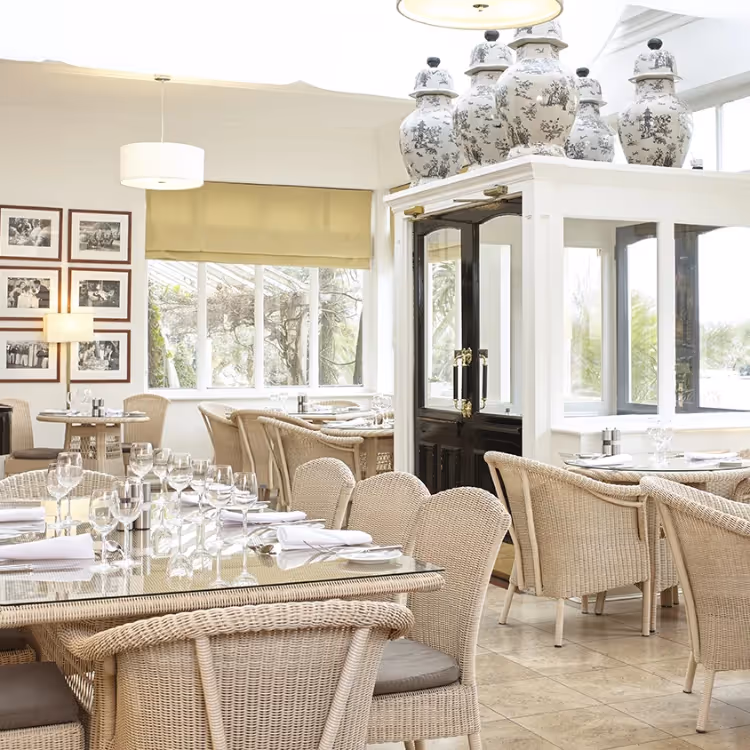 An elegant hotel conservatory with wicker furniture