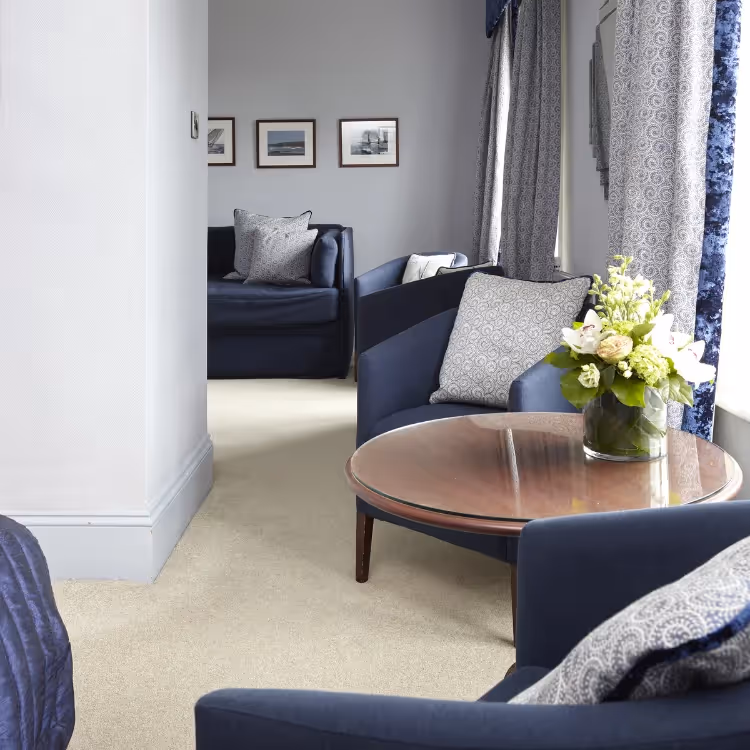 A modern hotel bedroom decorated in grey and navy blue