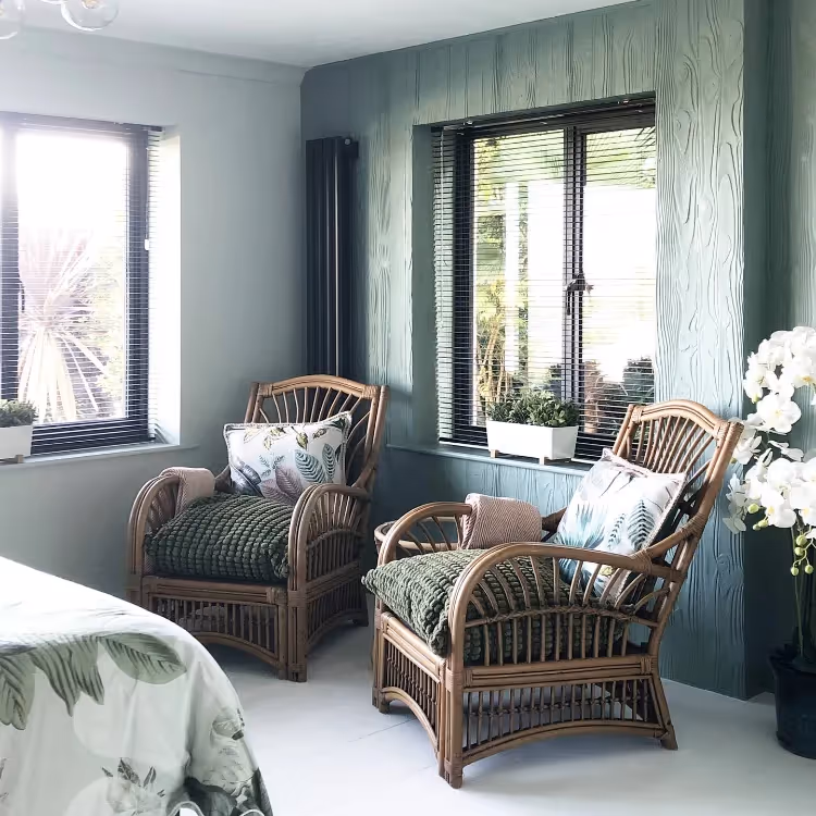 Wicker conservatory chairs in a green bedroom