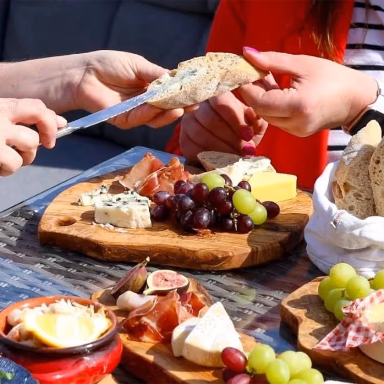 People tucking into a platter of cheese and charcuterie