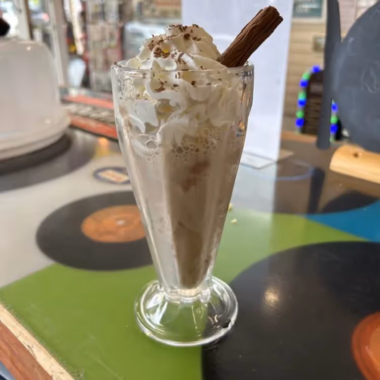 A chocolate shake topped with whipped cream and a flake