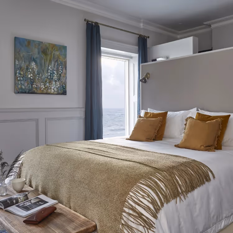 A seaside bedroom decorated in white with gold accents