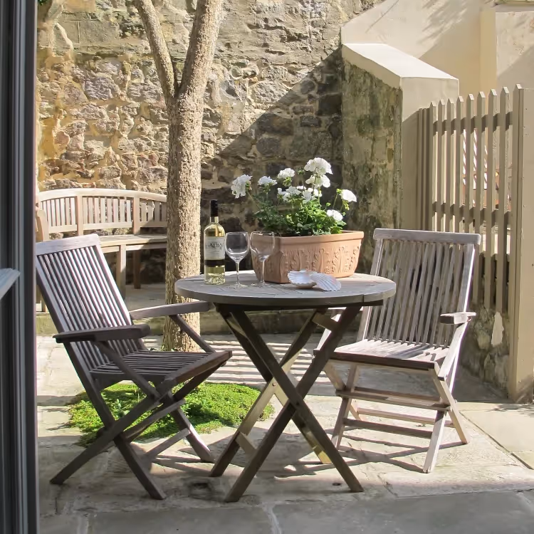 A small courtyard garden with teak table and chairs