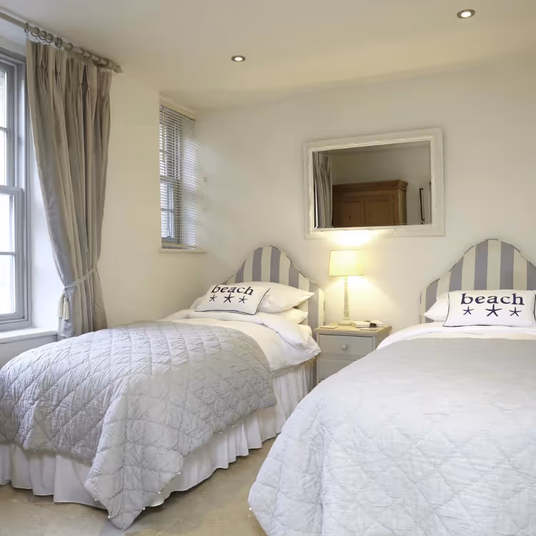 A twin bedroom decorated in cream and french blue