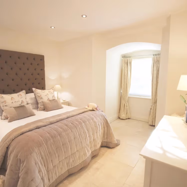 A bedroom softly decorated in cream and antique pink