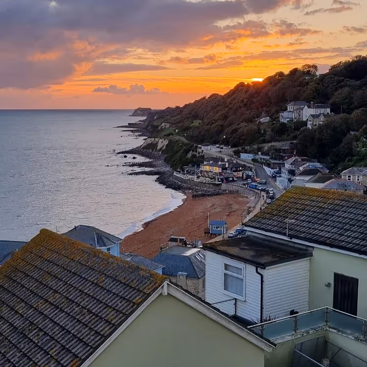 Looking down over a seaside town with a sunset in the background