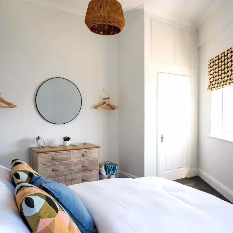 A white bedroom with blue and terracotta accents