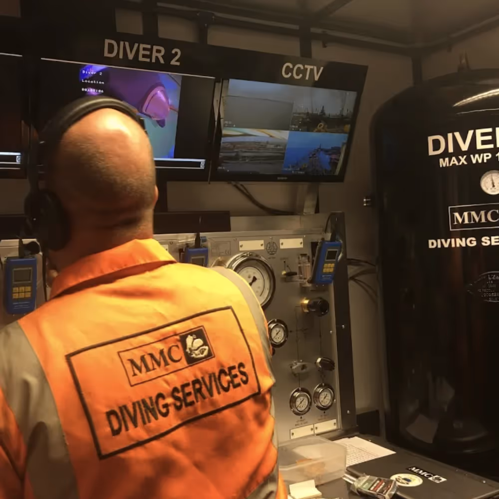 A diver watching CCTV in a control room