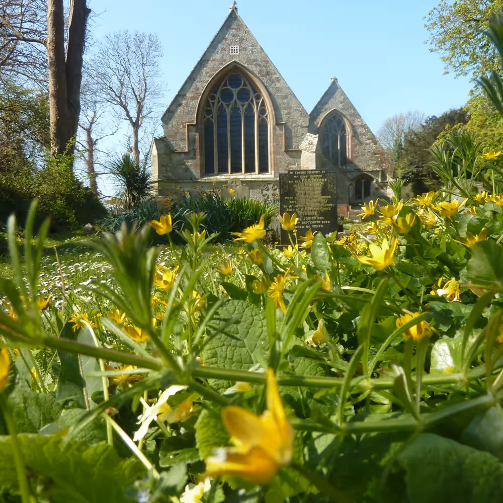 An old stone church with spring flowers in the foreground
