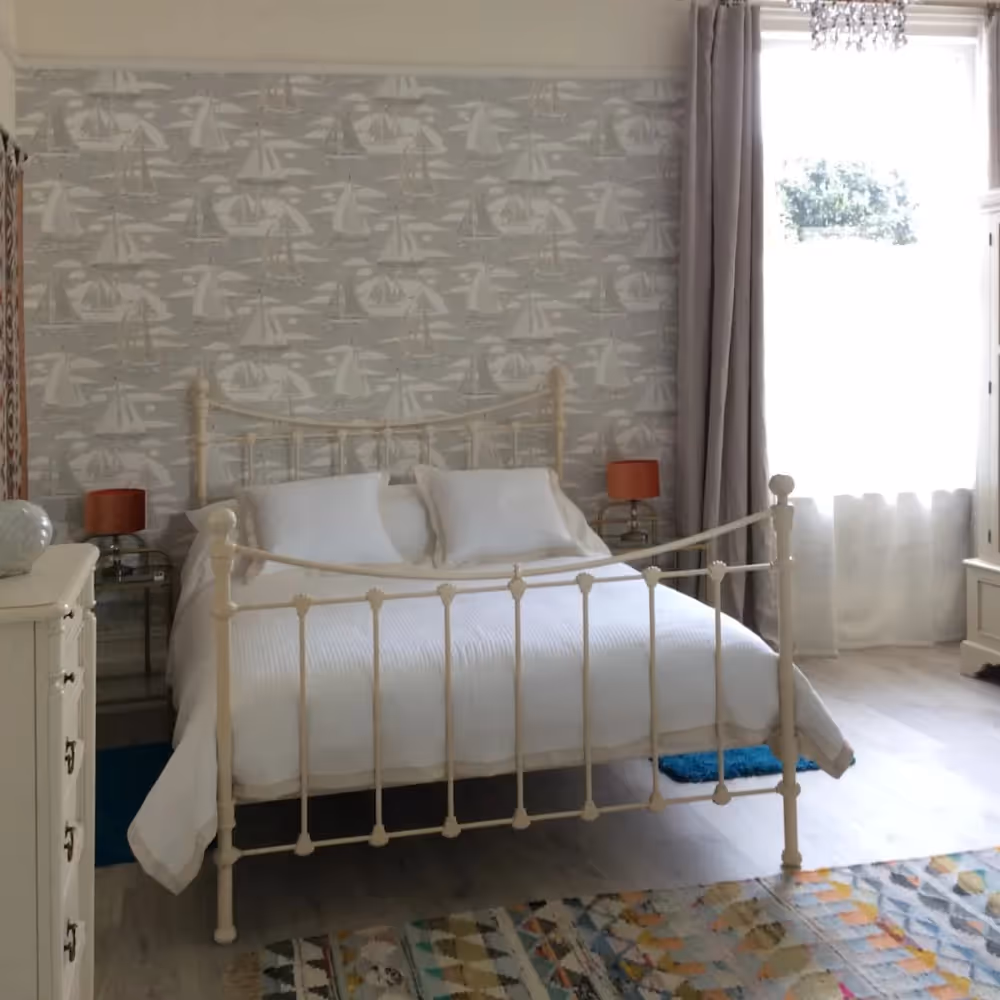 A traditional metal bedstead in a bedroom decorated in soft grey