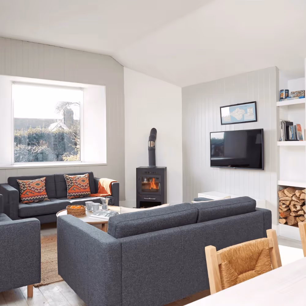 A modern living room with grey sofas and white walls