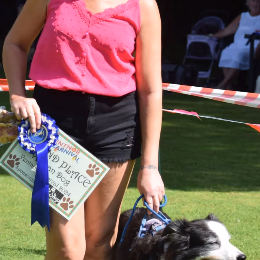 A woman and her dog collecting a prize