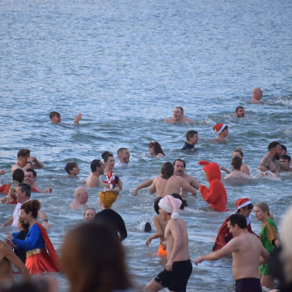 People running into the sea at a Boxing Day swim