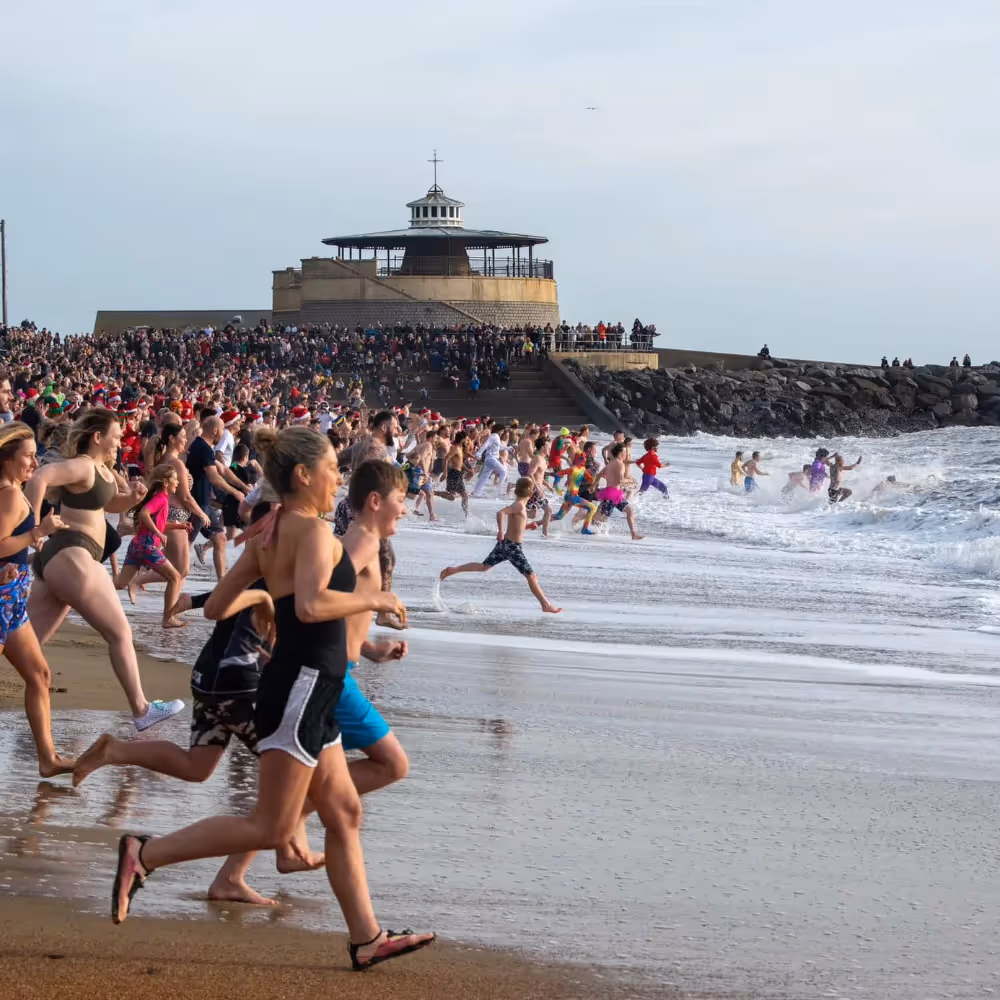People running into the sea at a Boxing Day swim