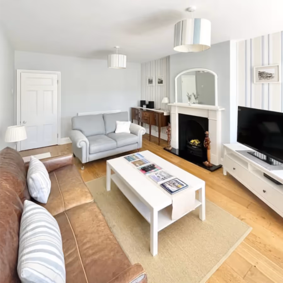 A large living room with white walls and wooden floors