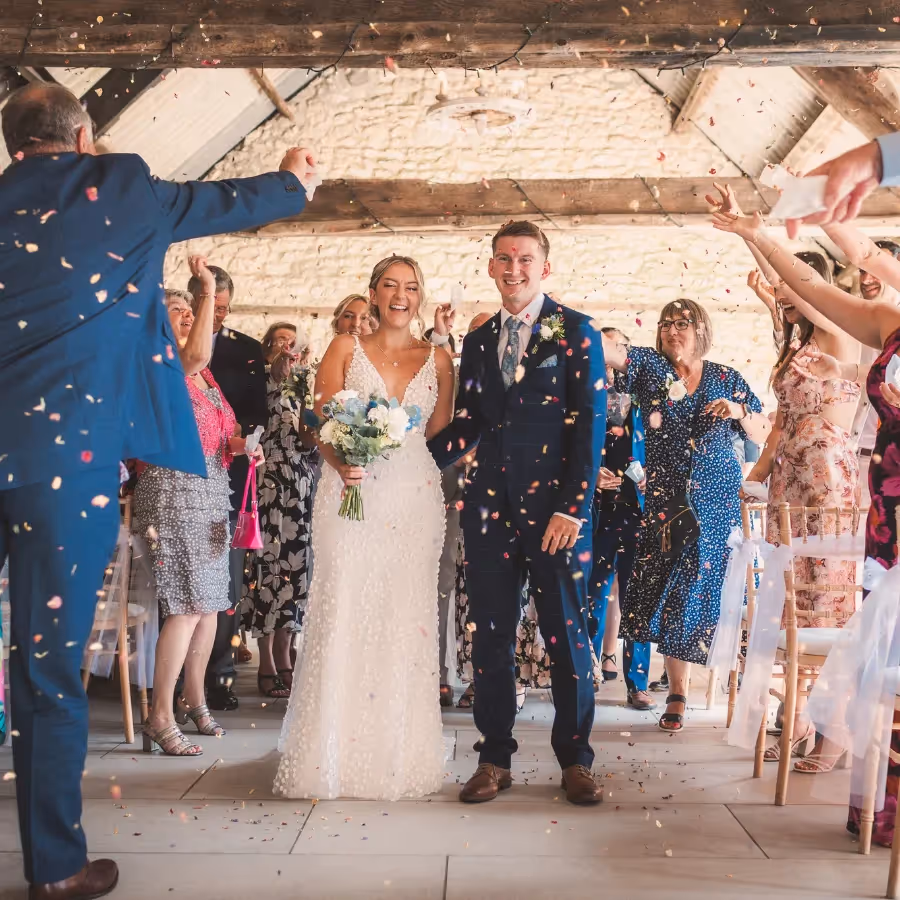 A bride and groom being showered in confetti