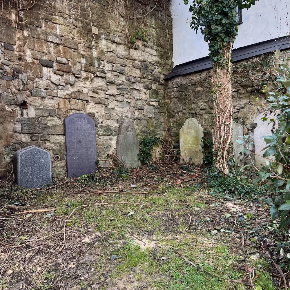 Gravestones leaning up against a wall