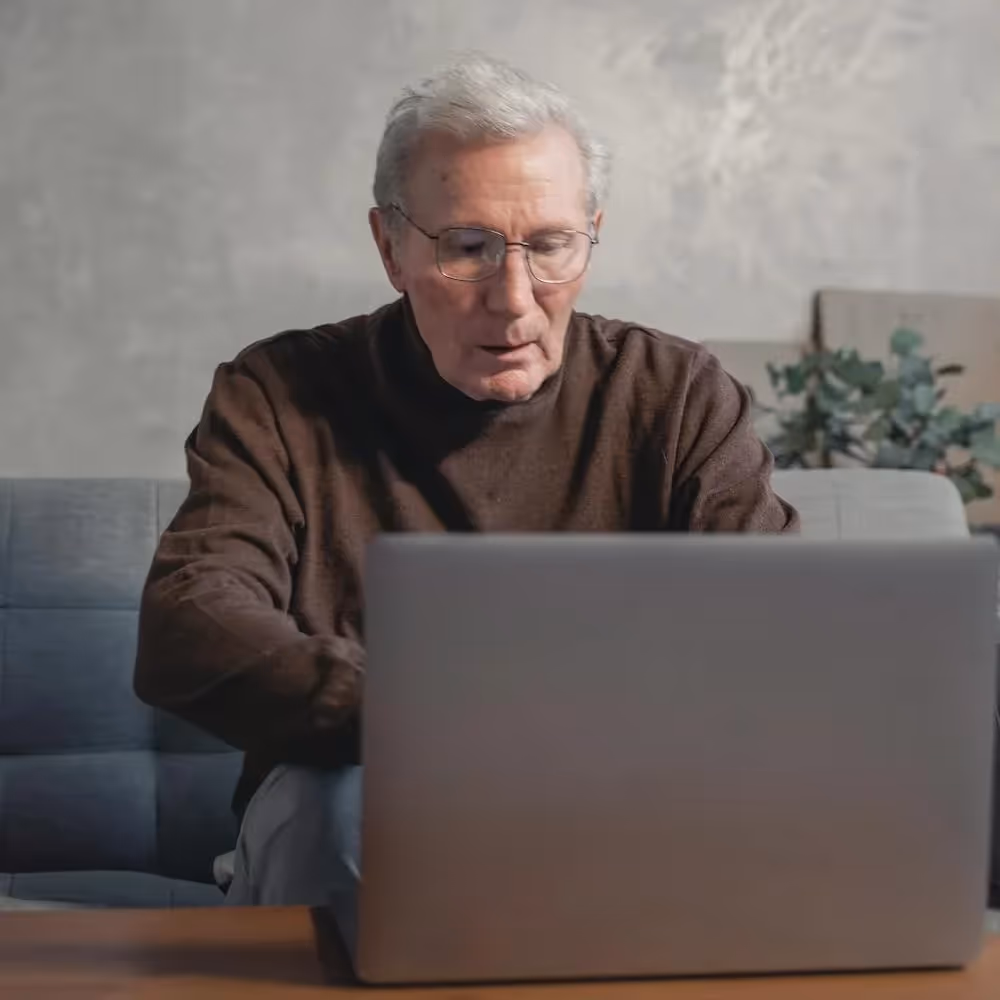 A senior man using a laptop