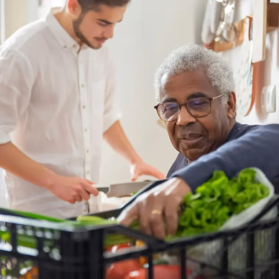 A man preparing a meal for a senior person