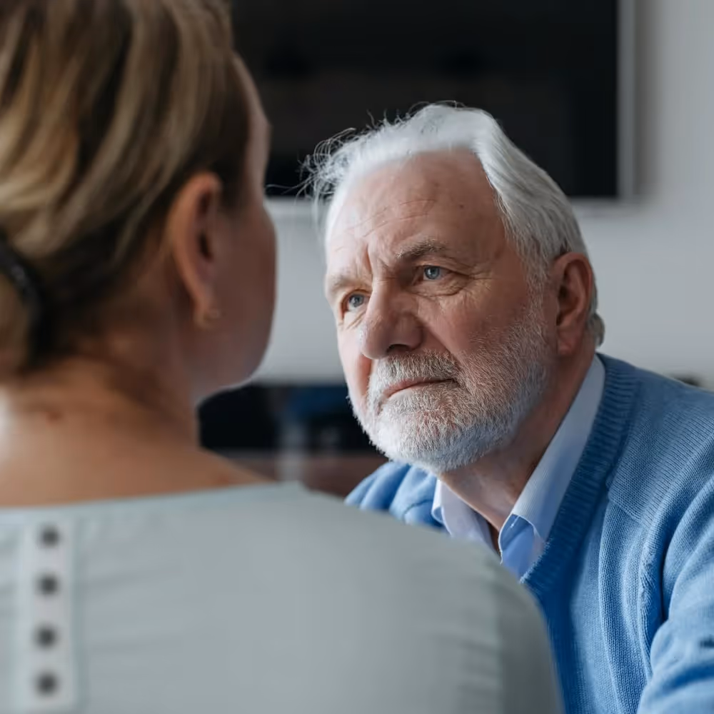 A woman talking to an senior man