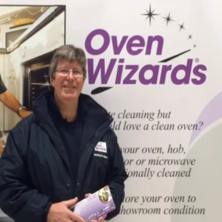 A man stood in front of a graphic for a company called Oven Wizards