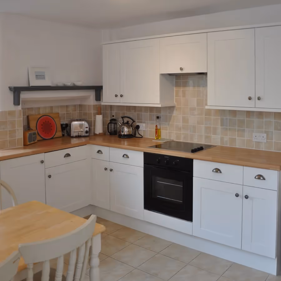 A white shaker kitchen with wooden worktops