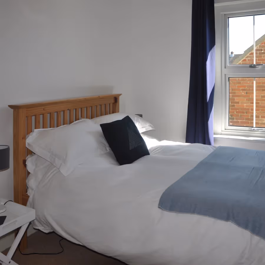 A neutral bedroom with a pine bedframe