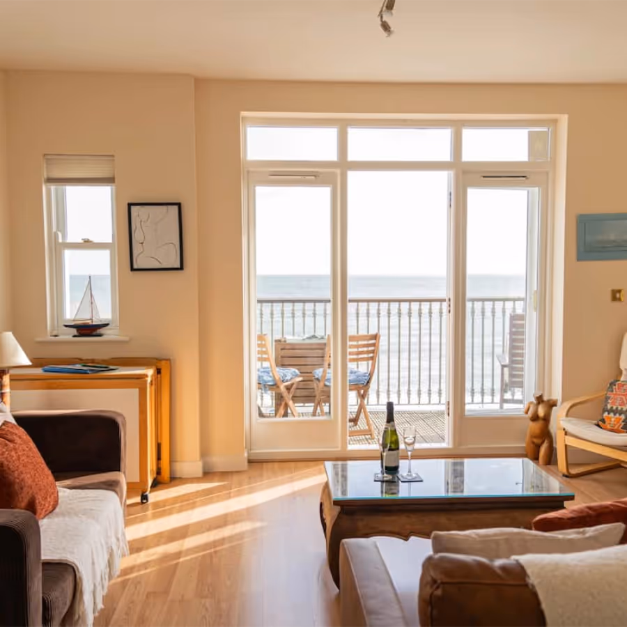 A living room with french doors looking towards the sea