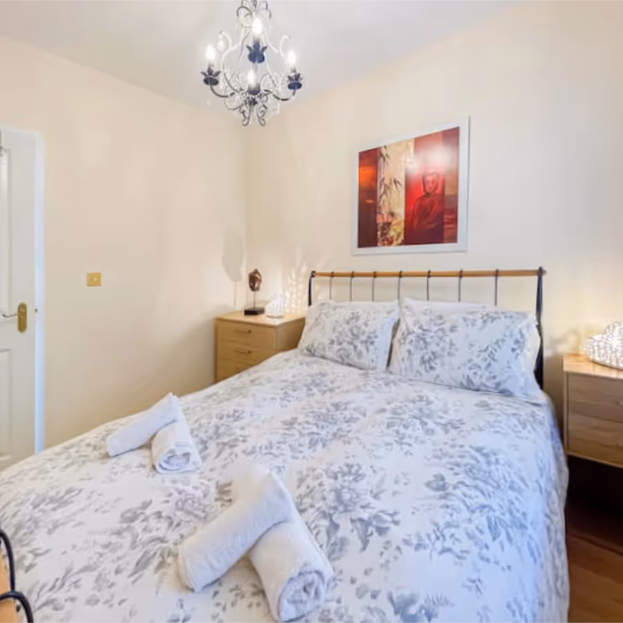 A neutral bedroom with brass bed and blue and white bedding