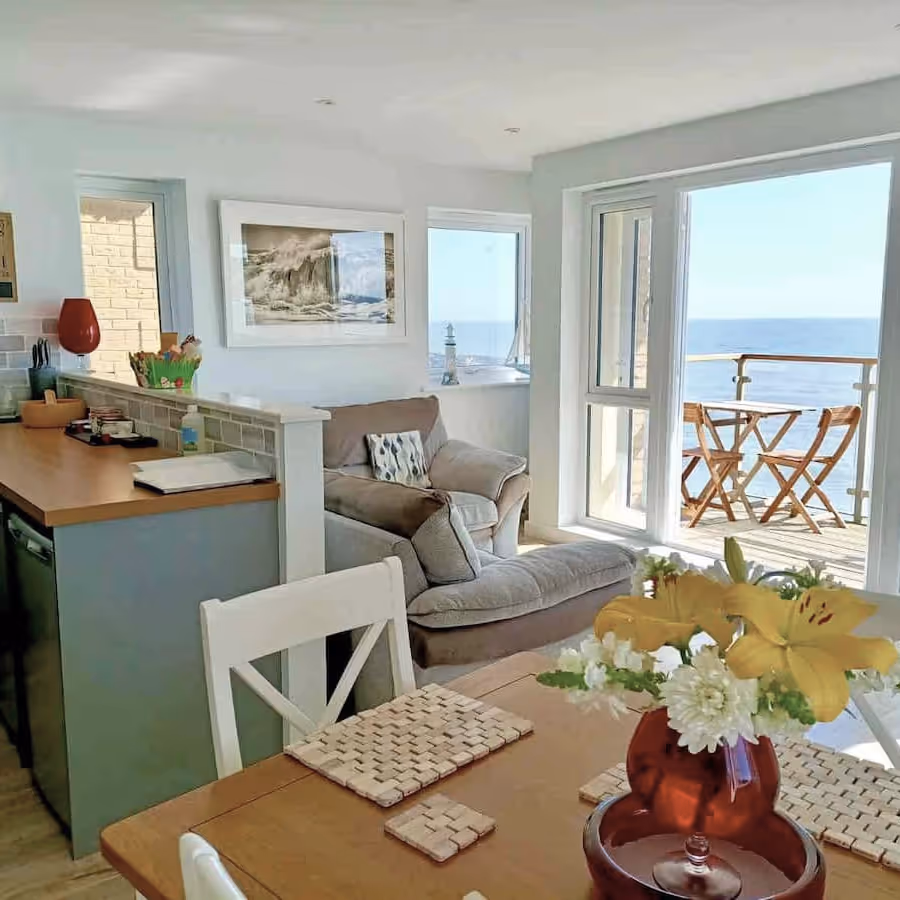 An open plan living room and kitchen with sea view.