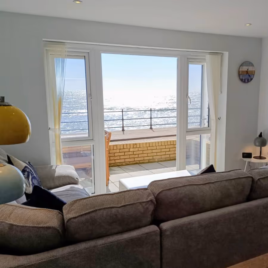 A view from a sofa out the french doors to the sea beyond