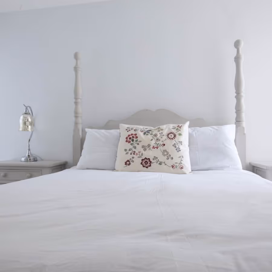 A white bedroom with a French style bed