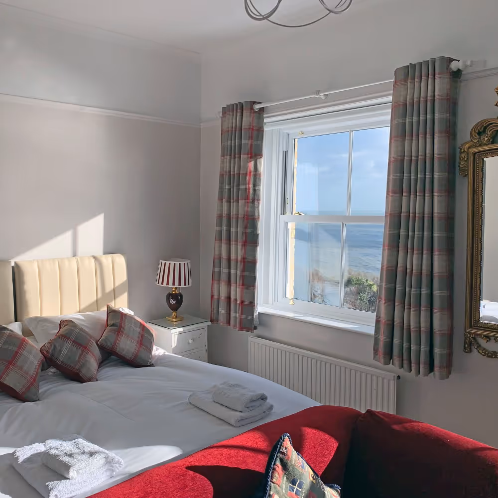 A neutral bedroom with a red sofa