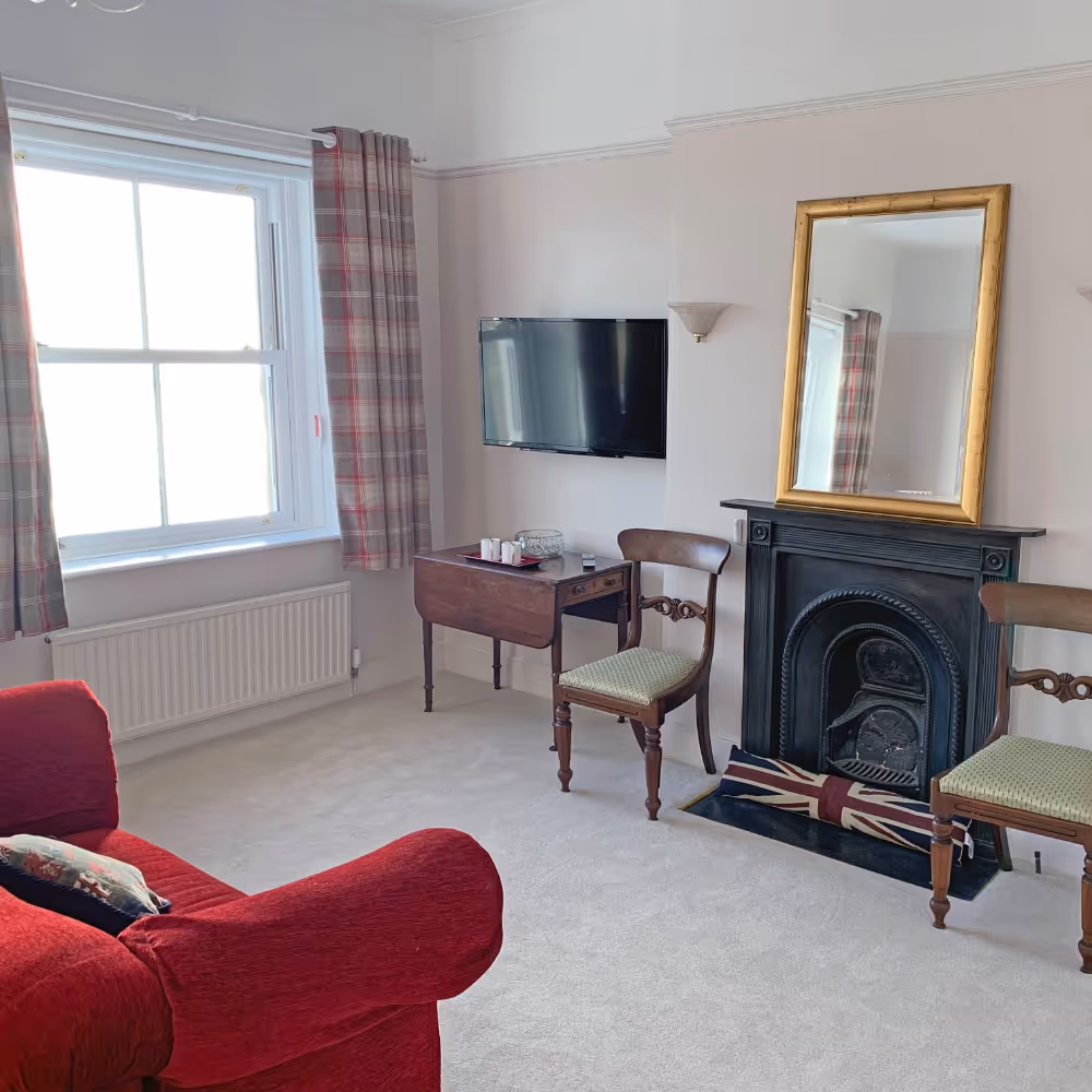 A room with a red sofa and antique furniture