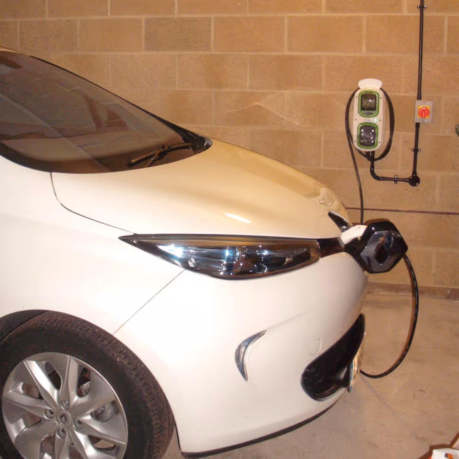 A white car connected to an electrical vehicle charging point