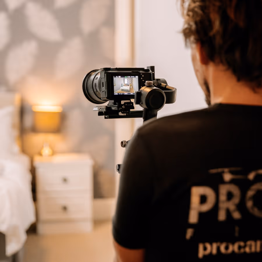 A professional photographer taking a photo of a bedroom