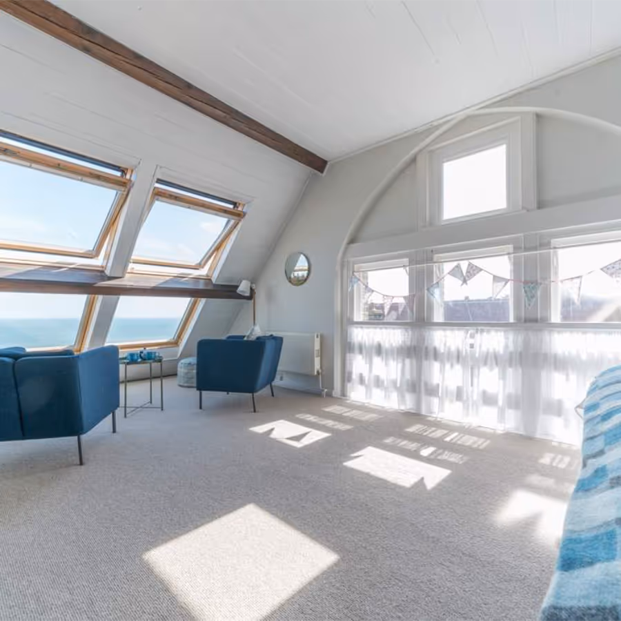 A modern attic bedroom with a sea view