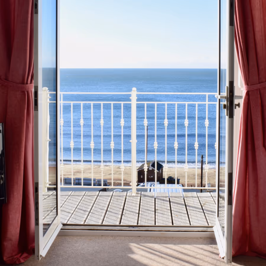 Patio doors opening onto a balcony with a sea view