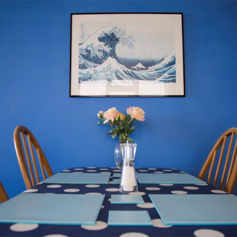 A blue dining room with glass table