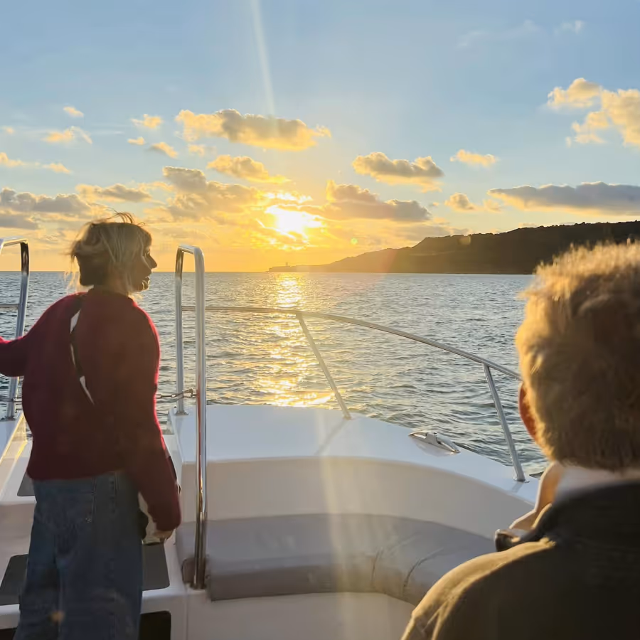 Two people on a boat looking at the sunset