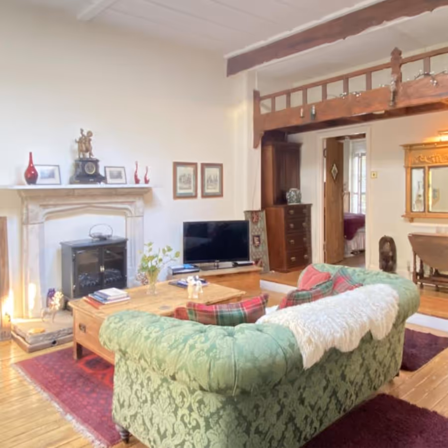 A country living room with traditional furnishings and stone fireplace