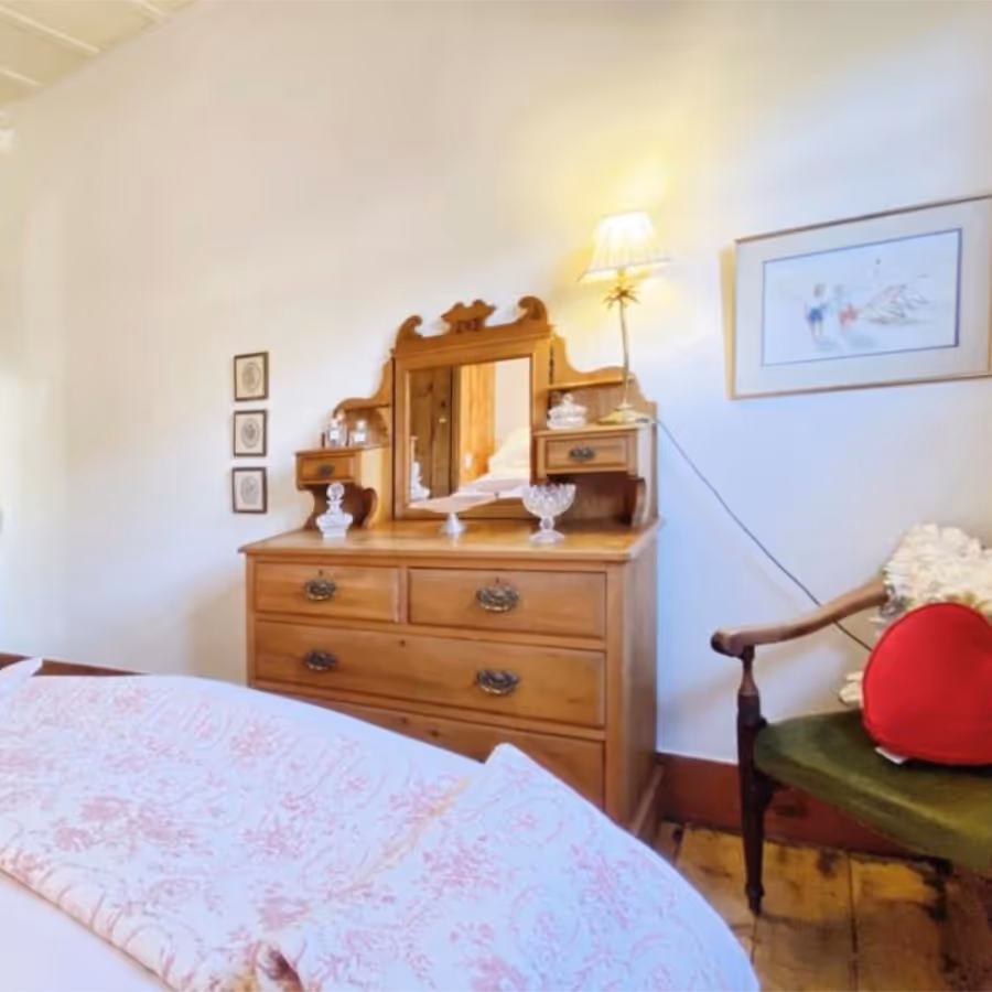 A bedroom with an old pine chest of drawers