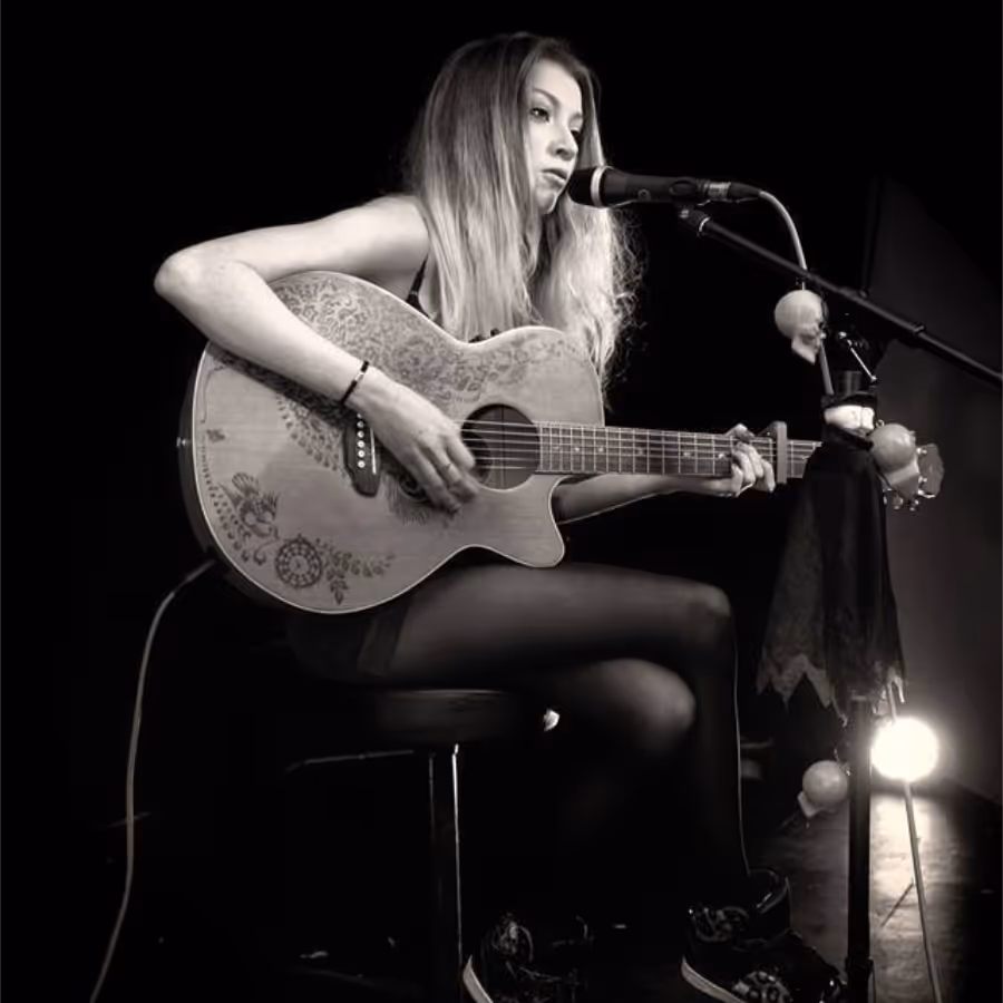 A black and white photo of a lady playing guitar