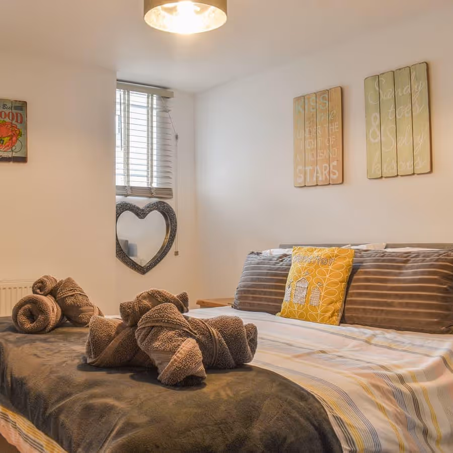 A small bedroom with beige an yellow decoration