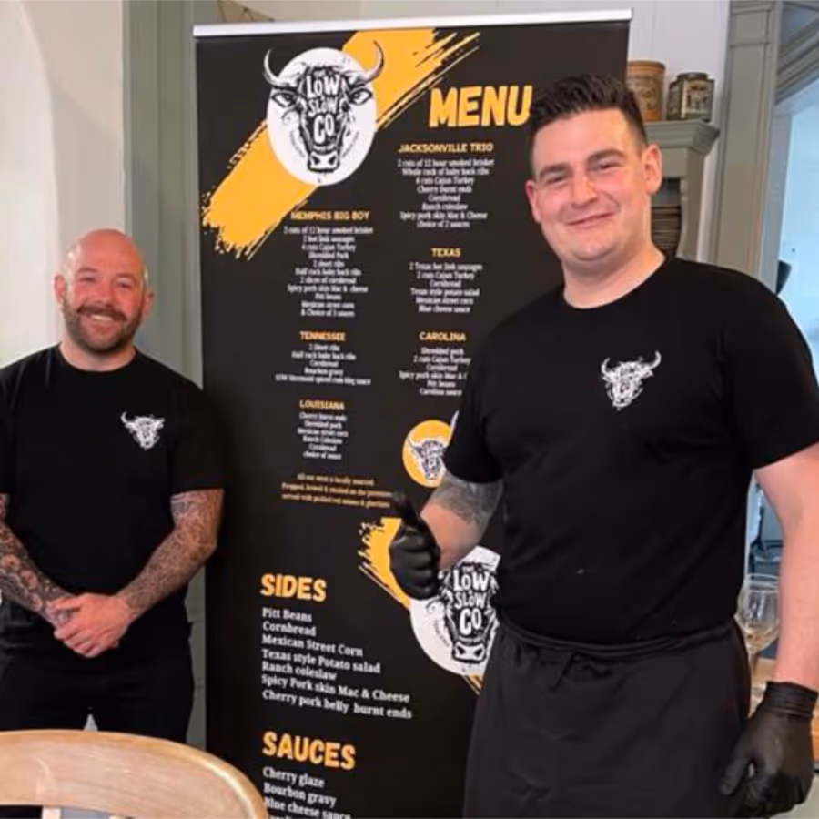 Two men stood in front of a stand up banner menu