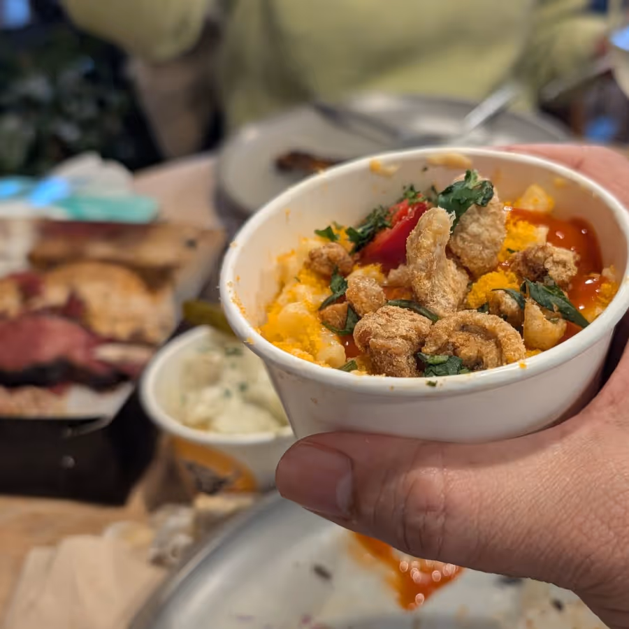 A hand holding a pot of mexican beans