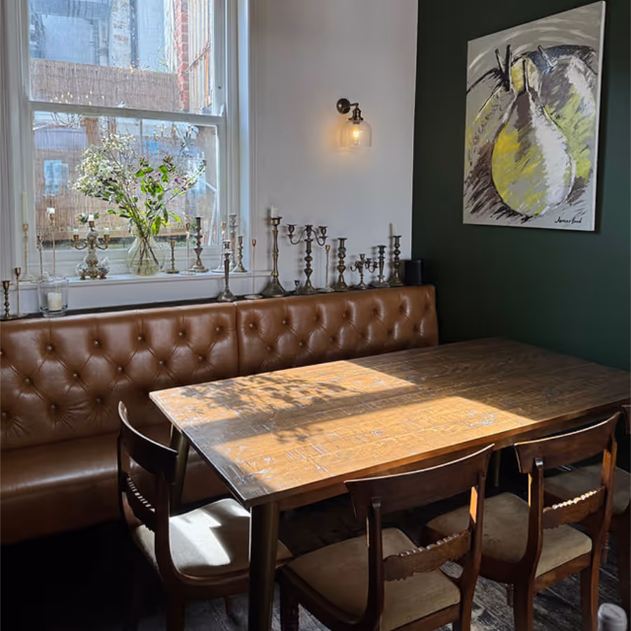 A table and buttoned leather banquette seating in a restaurant
