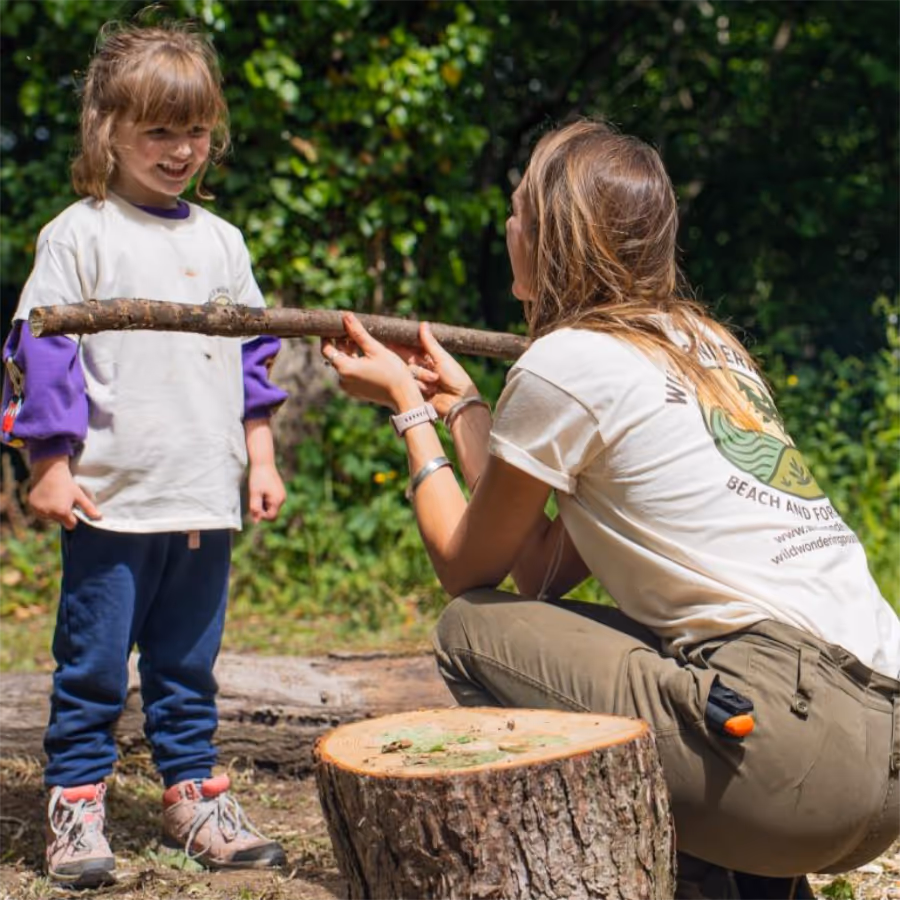 A lady teaching girl skills in a forest